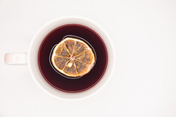 Xícara de chá de Hibisco, vermelho com rodela de laranja desidratada no chá. Tons de vermelho,...