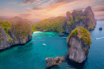 Aerial view paradise Nui beach, turquoise lagoon with white coral sand and palms on sunset time....