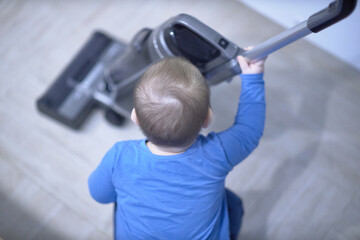 Little Boy Gripping Metal Object While Cleaning the House
