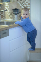 Little Boy Standing on Stool in Kitchen