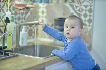 Little Boy Standing in Front of a Kitchen Sink