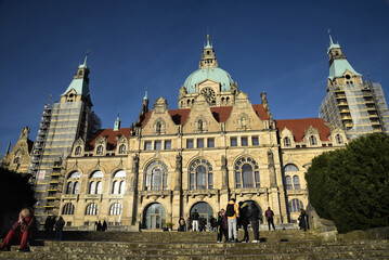 Naklejka na ściany i meble Hannover - People enjoying a sunny day, walking in front of the New Town Hall.
