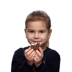 Cute little girl with a chocolate candy in her hands, eating and smiling