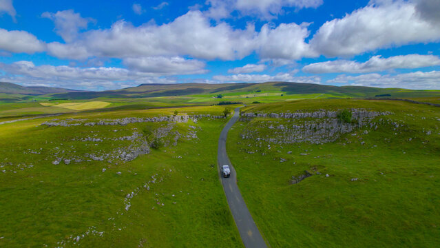 AERIAL: Modern camper van travels through picturesque countryside in Yorkshire