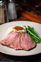  pouring brown gravy sauce on roasted beef