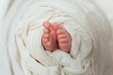 a baby's foot is wrapped in a white blanket.