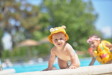 A small child near the pool without adult supervision, danger.
