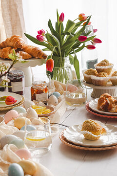 Cozy Easter breakfast table with pastries and spring decor