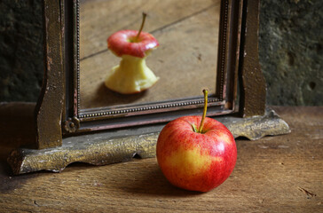 Surrealistic image with apple reflecting in the mirror.