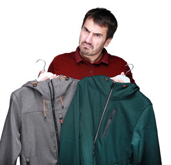 A dark-haired man of 40-45 years old holds a hanger in his hands, the concept of buying and choosing clothes