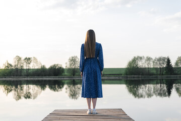 young woman stands at pier
