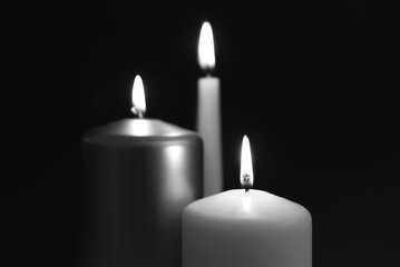 Burning candles on dark surface