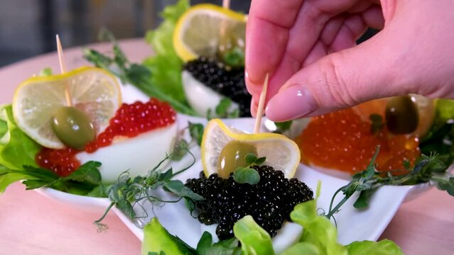 And black caviar to make boats out of lemon on toothpicks for decoration in a snack restaurant Boiled eggs in a bowl decorated with parsley leaves