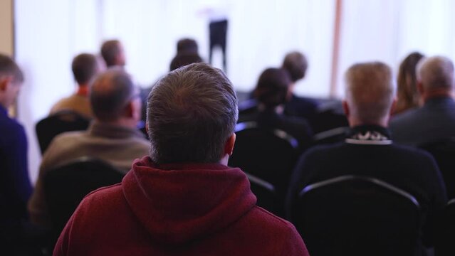 Audience at the modern conference hall listens to panel discussion, people on a congress together listen to speaker on stage at convention, business seminar, amphitheater venue for presentation