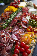 Fototapeta premium Close-up photo of a gourmet charcuterie board featuring a variety of cured meats, artisan cheeses, and gourmet accompaniments, arranged with artistic flair.