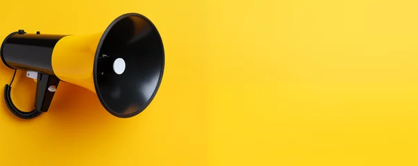 Tuinposter Black megaphone on yellow landscape background with copyspace  © ammad