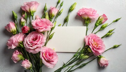 Beautiful pink Eustoma flowers and card with space for text on light background, flat lay 