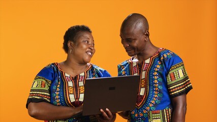 Smiling african american people look at website on laptop, scrolling through social media network...