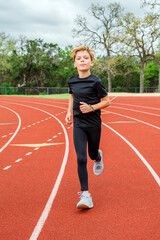 Young male track athlete running in his lane during a race
