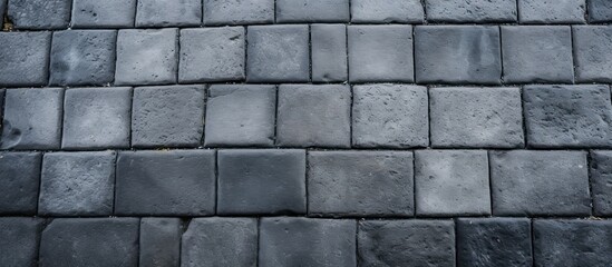 A detailed shot of a roof constructed with rectangular grey tiles, showcasing the intricate brickwork pattern and building material used
