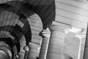 Striking repetition of stone arches and columns in the crypt of the Pantheon, Paris, France. Black and white image.