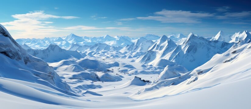 Snowy mountains under blue sky with clouds