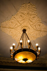Old chandelier in retro style with incandescent lamps, lighting with electricity in a manor house