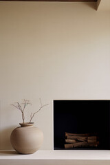 Minimalist still life photography of a ceramic vase with dry branches in front of a fireplace