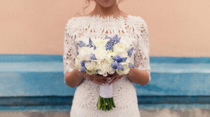 Blue Muscari Neglectum for spring wedding bouquet in the hands of the bride. Selective soft focus,...