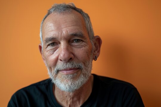 Portrait of a senior man with a white beard on a orange background