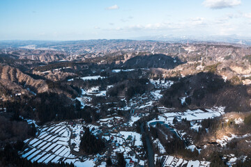 ドローン写真：雪が溶けつつある田舎の山と、広がる青空と雲