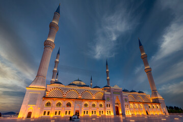 Dusk settles over the Camlica Mosque, with its illuminated minarets piercing the evening sky in...