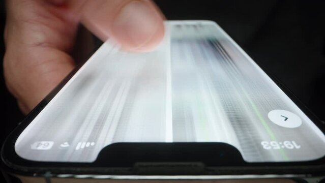 A Man in his Phone Quickly Flips Through Pictures, A Blurry Image. Macro frame