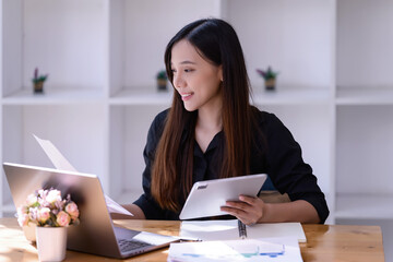 Businesswomen working online meet in front of a laptop in the office.