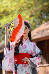 Young women wearing traditional Japanese kimono or yukata is happy and cheerful in the park.