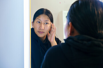 latina woman scrubbing wrinkles from her face - beauty concept