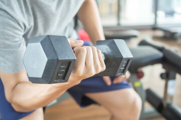 man is lifting the Dumbbell up and down for strengthen her arms and shoulders. exercisers and are...