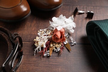 Wedding stuff. Composition with stylish boutonniere on wooden background