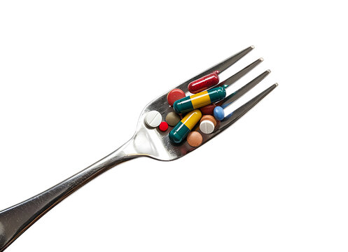 A fork beside pills against a white background.












