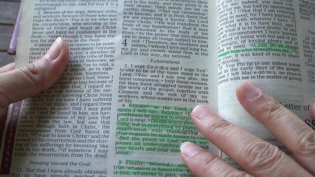 Book of Philippians of the new testament in the Holy Bible. Turning page to chapter 4 with highlighted verses 4-7. 