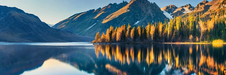 Fototapeten Mountains towering over a serene lake © babarkhan