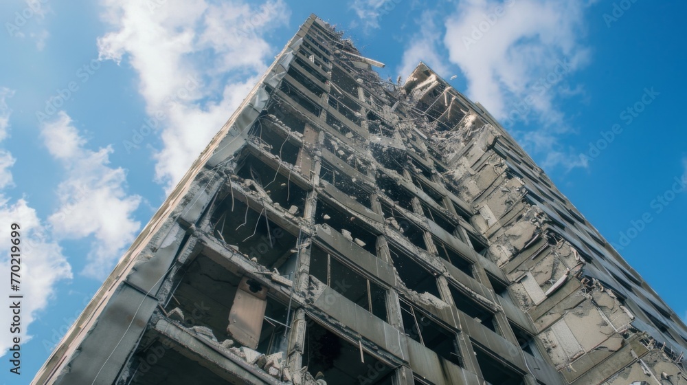 Poster a towering building with shattered windows and chunks of concrete missing from its structure.