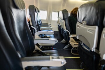 seats inside a plane with seatbealts and chairs in economy seats on an airplane