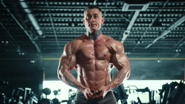 A well-built bodybuilder poses powerfully in the gym, his rippling muscles testament to countless hours of dedication and hard work in bodybuilding. Camera 8K RAW. 