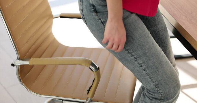 Woman employee stands up from cozy chair in office