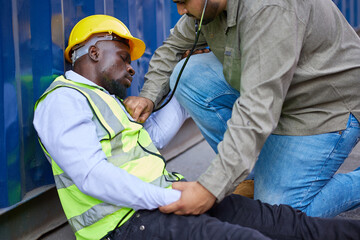 worker or engineer lying unconscious and doctor try to helping in containers warehouse storage