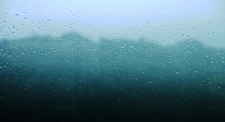 梅雨　雨の滴のついた窓ガラスの奥の山の風景　6月・梅雨明け・水滴
