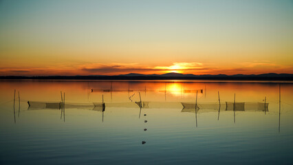 Poaching fishing nets. Landscape view of the lake at sunset. The concept of saving the planet and...