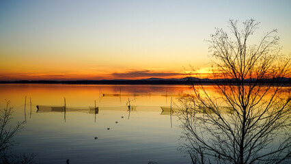 Poaching fishing nets. Landscape view of the lake at sunset. The concept of saving the planet and...