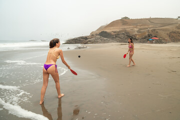 Latin women playing table tennis on the beach